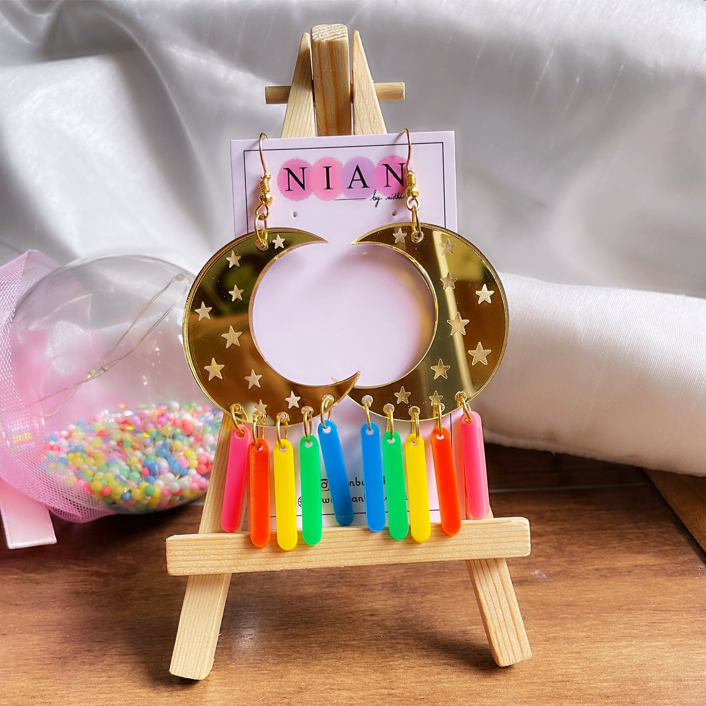 Moon Earrings - Multi-color - Nian by Nidhi - in a white and brown background, placed on a small wooden canvas