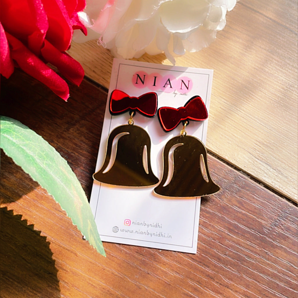 Jingle Bell Earrings - Red and Golden- Nian by Nidhi- placed in a brown and flowery background
