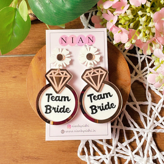 Team Bride Floral Earrings - Rosegold and White - Nian by Nidhi - placed in a colorful background
