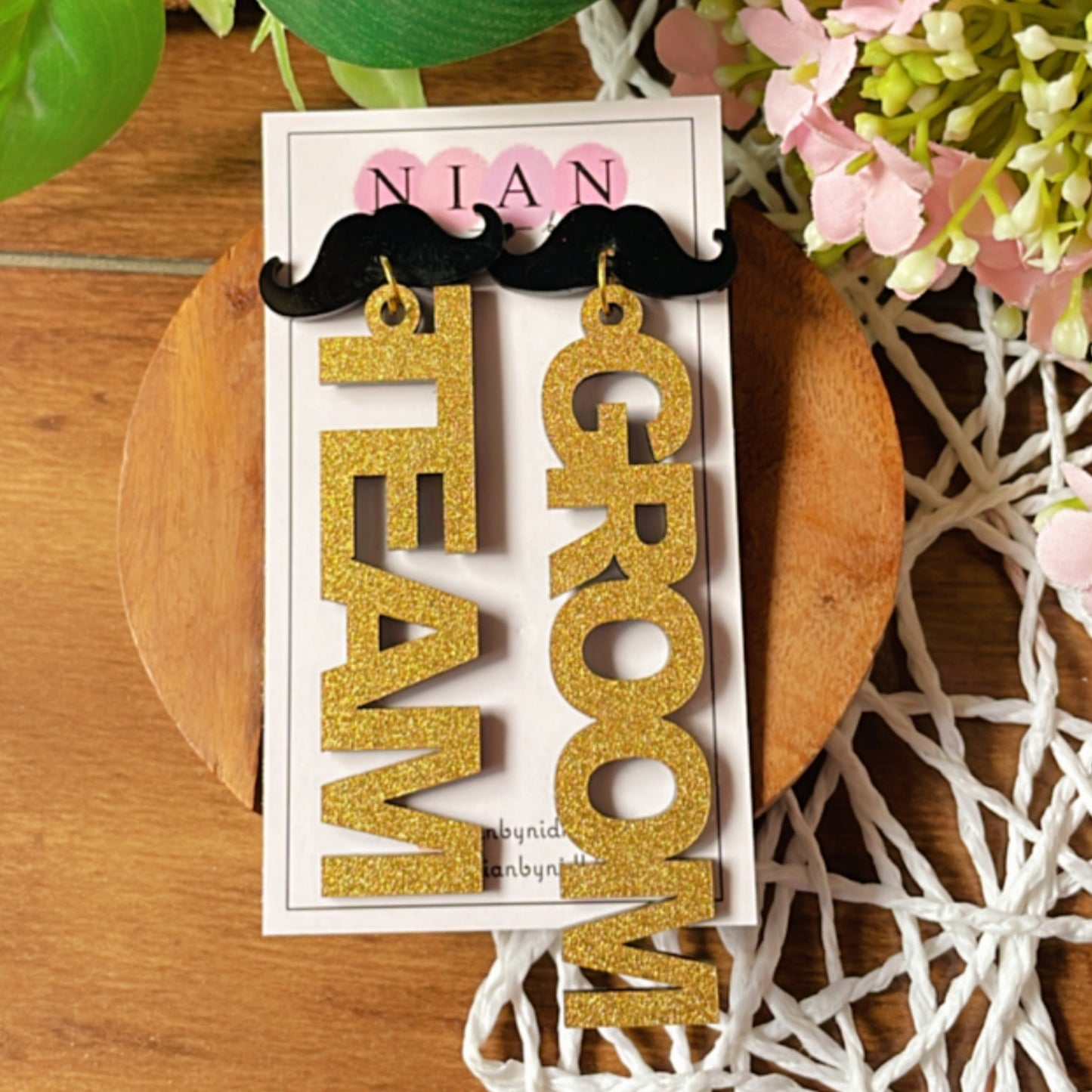 Team Groom Moustache Earrings - Shimmer Golden and Black - Nian by Nidhi - placed in a colorful background