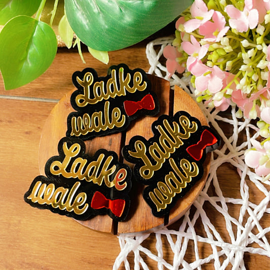Ladke Vale Brooch Pin - Glossy Golden and Red - Nian by Nidhi - placed in a colorful background