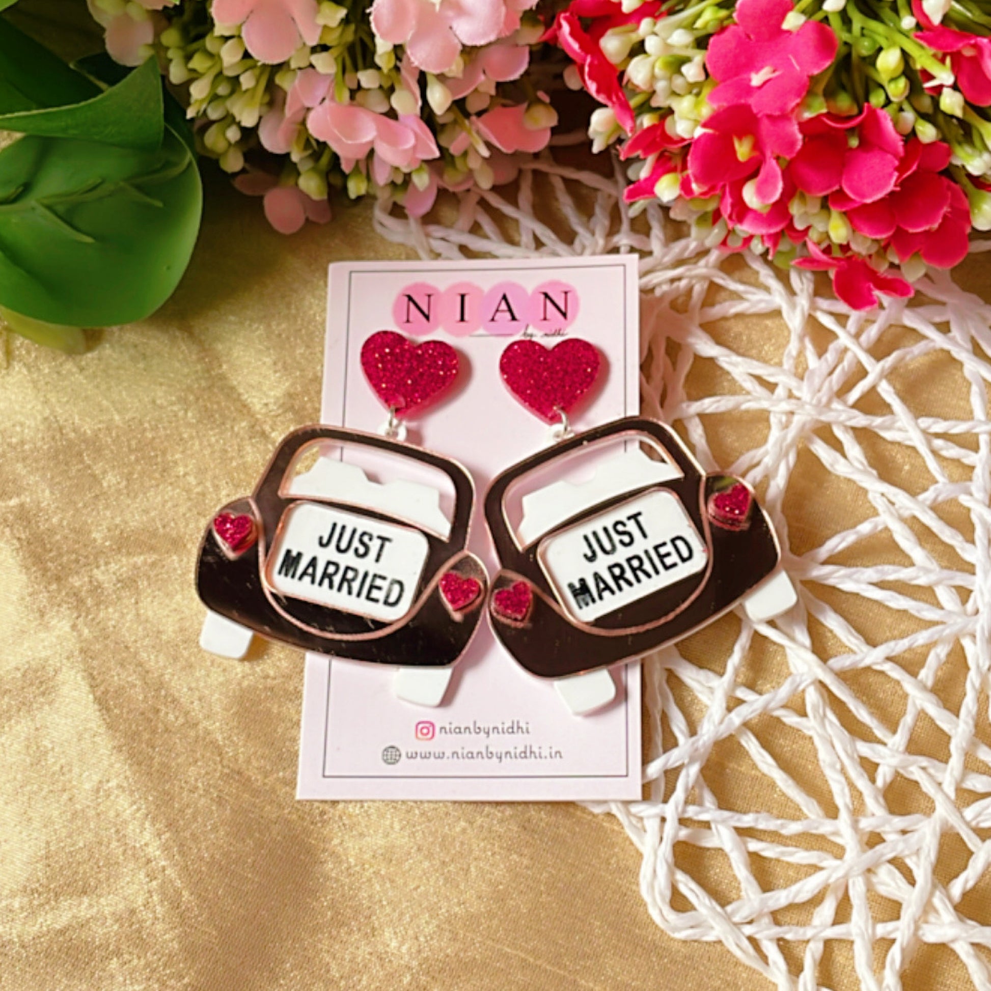 Just Married Earrings - Rosegold, White, and Shimmer Magenta - Nian by Nidhi - placed in a colorful background