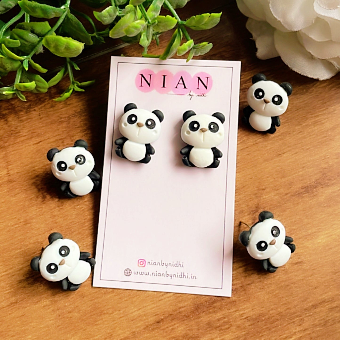 Perky Panda Studs - White and Black - Nian by Nidhi - placed in a white and green background