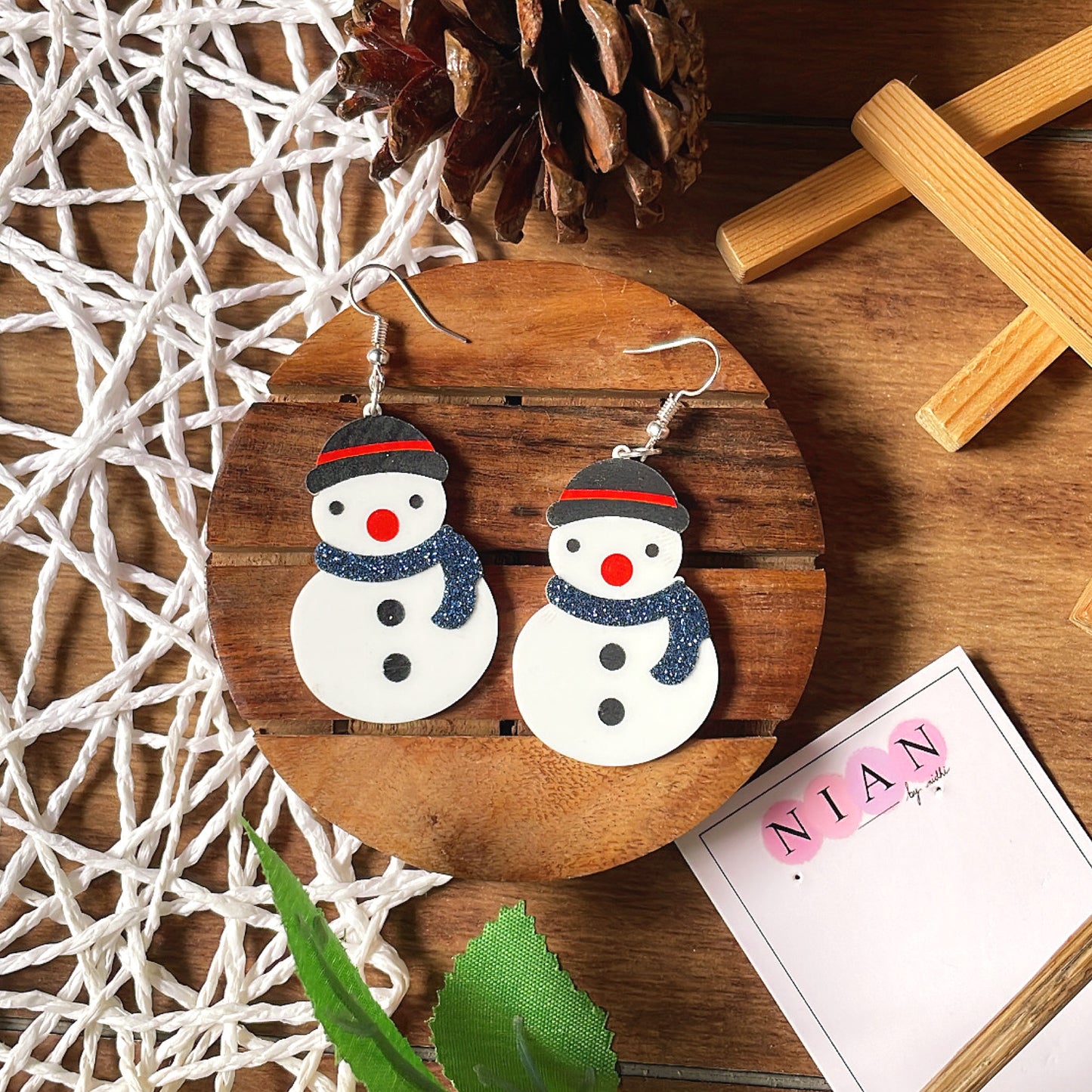Snowman Earrings - White - Nian by Nidhi - placed in a white and brown background