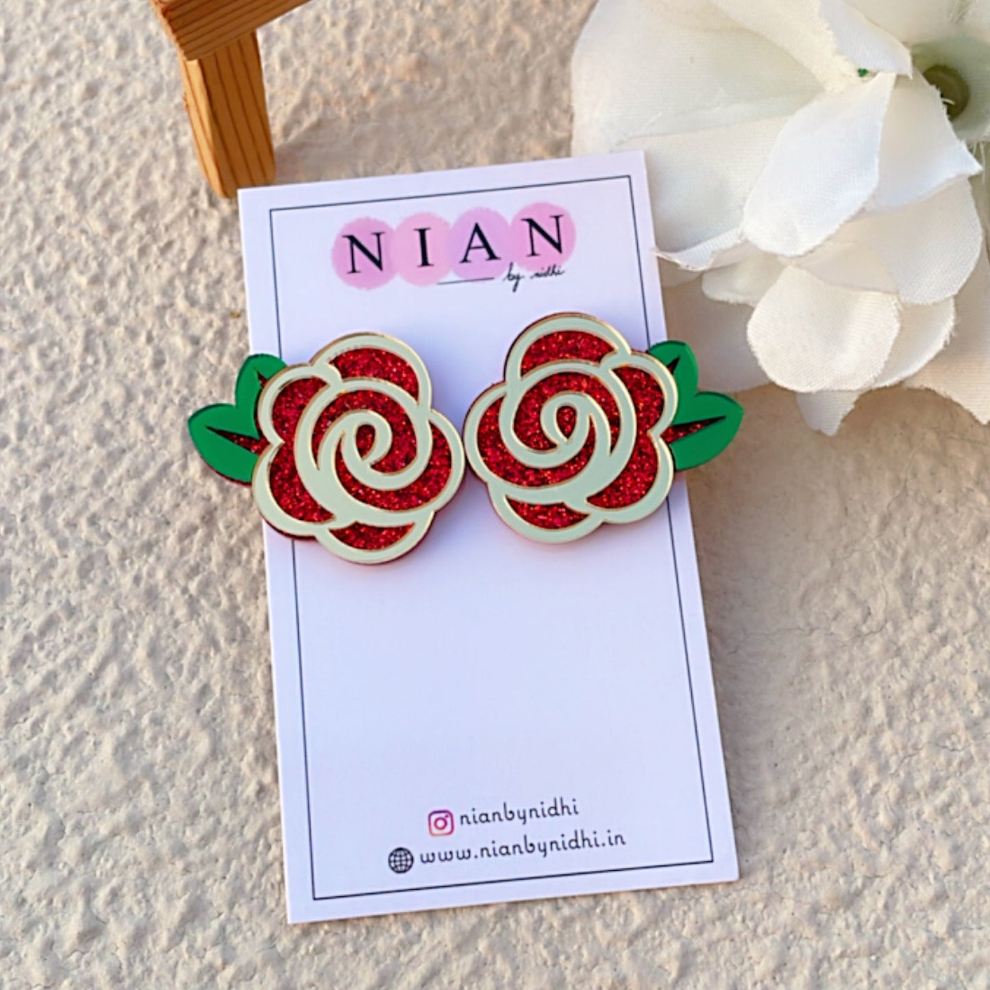 Ravishing Rose Earrings - Shimmer Red, Glossy Golden and Green - Nian by Nidhi - placed in a brown background