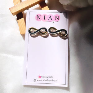 Infinity Studs - Glossy Golden and Silver - Nian by Nidhi - placed in a white and brown background