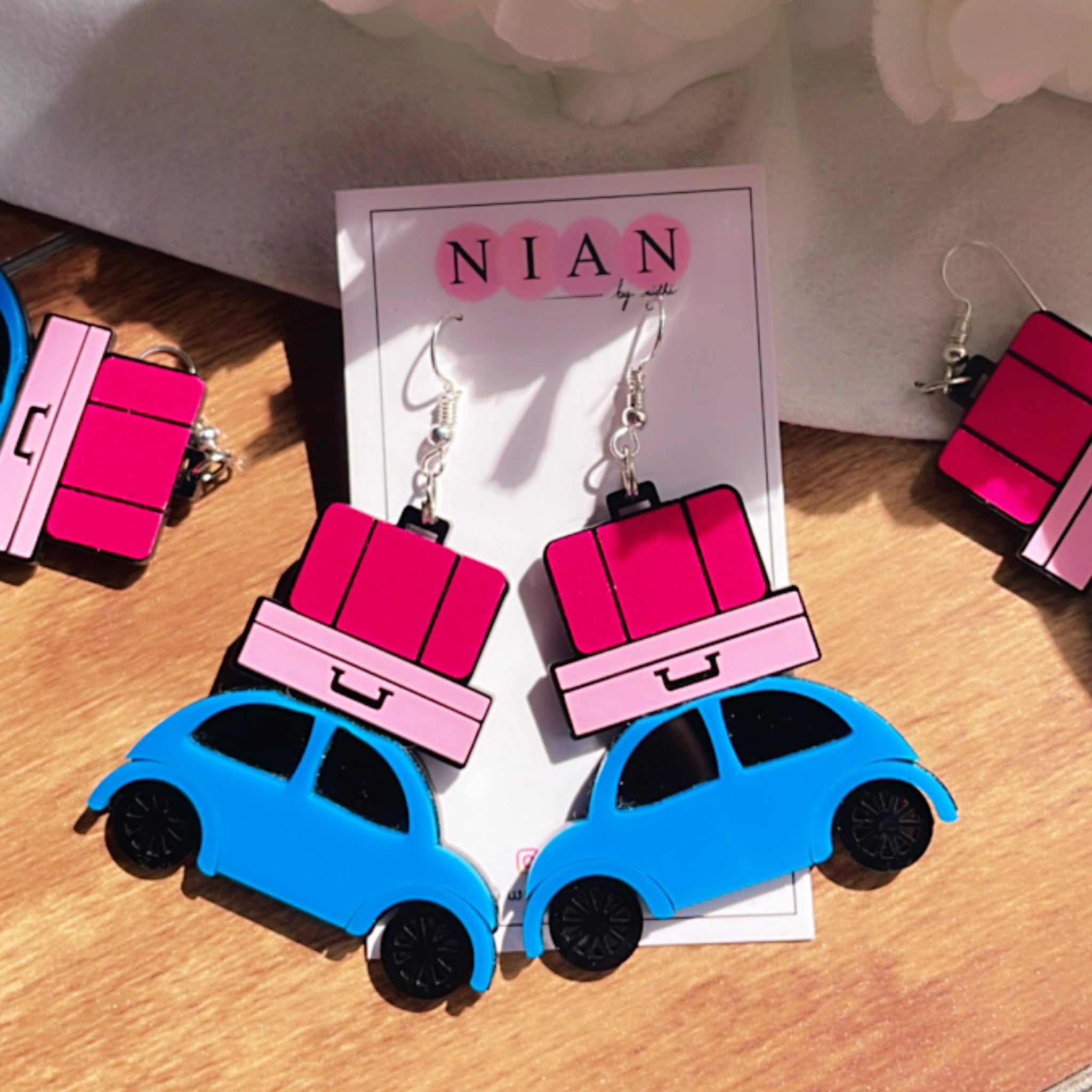 Happy Journey Earrings - Multicolor - Blue, Baby Pink, Dark Pink, Black - Nian by Nidhi - placed in a white and brown background