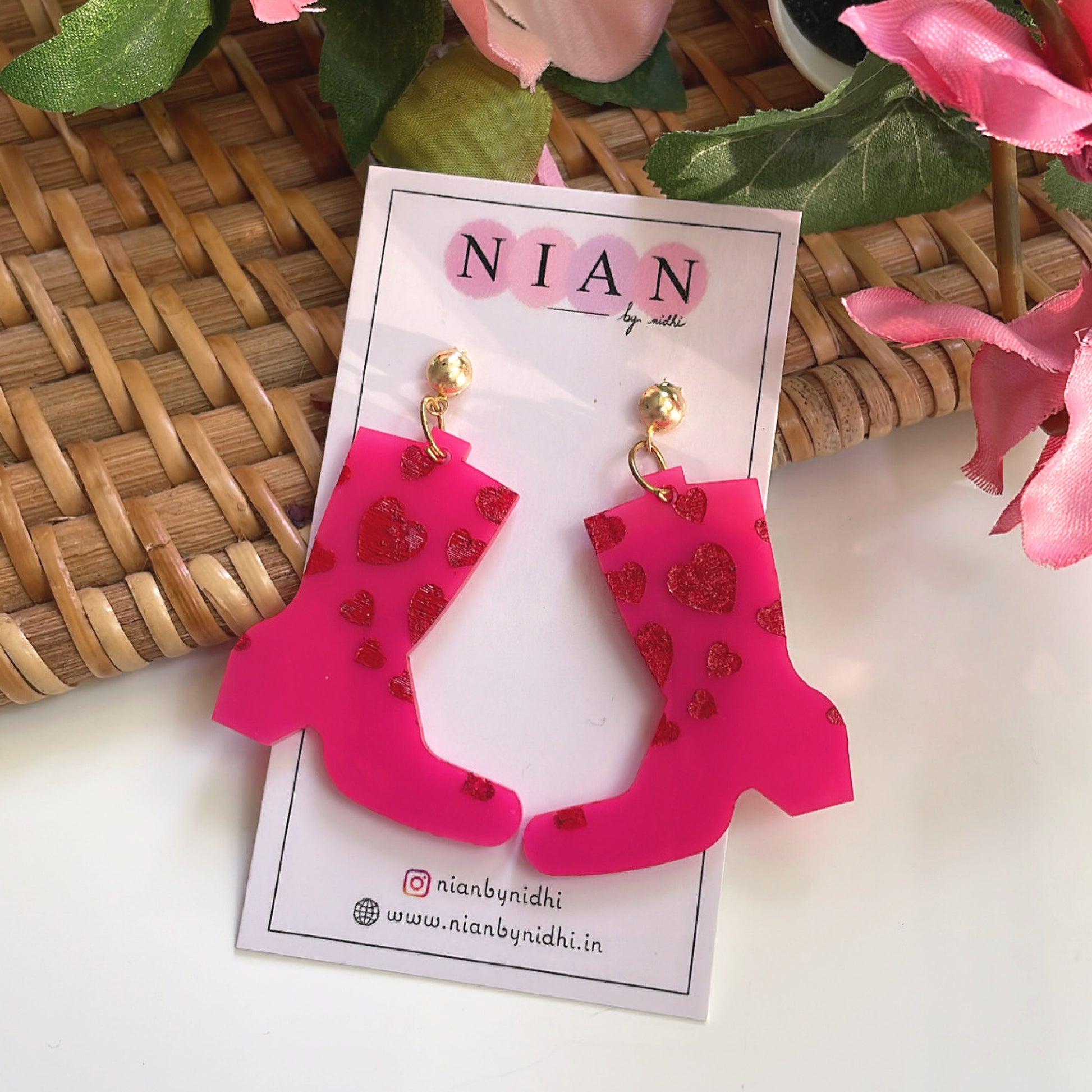 Splashy Rainboots Earrings - Pink and Red - placed in a white, brown, and pink background