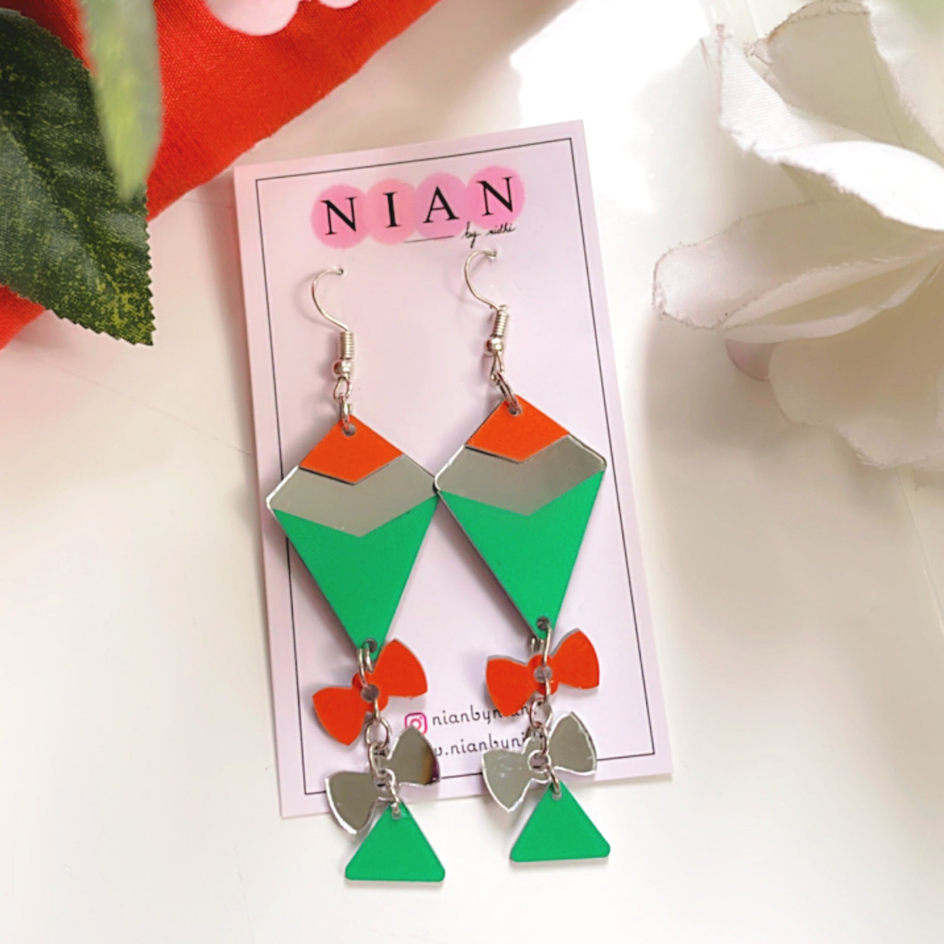 Palyful Patang Earrings - Saffron, Green and Glassy Silver - Nian by Nidhi - placed in a white background