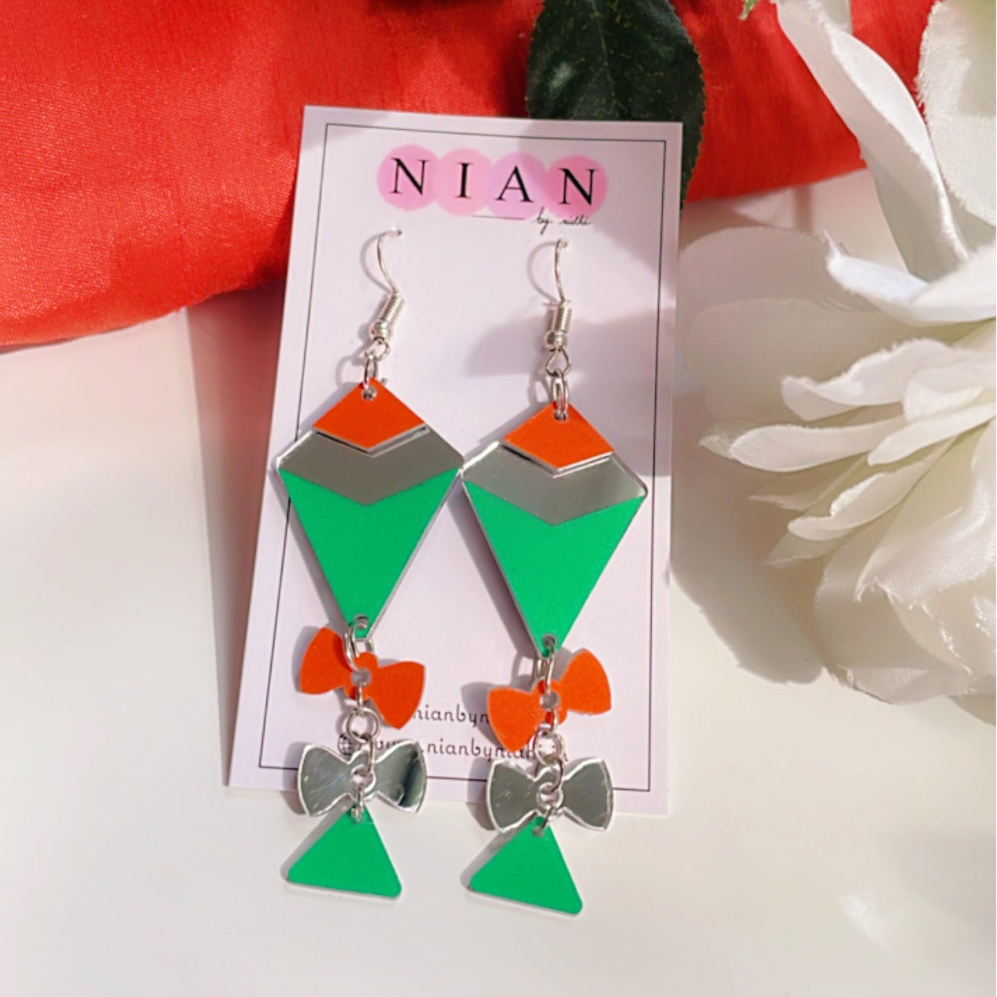 Palyful Patang Earrings - Saffron, Green and Glassy Silver - Nian by Nidhi - placed in a white background