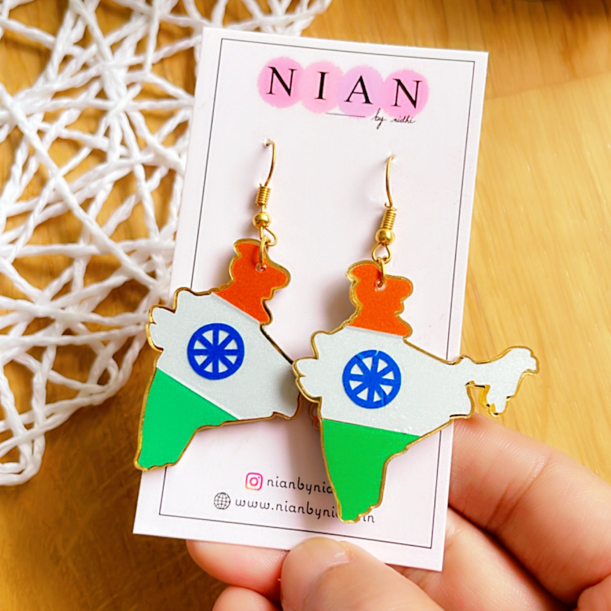 Jai Hind Earrings - Saffron, White and Green - Nian by Nidhi, placed in a brown and white background