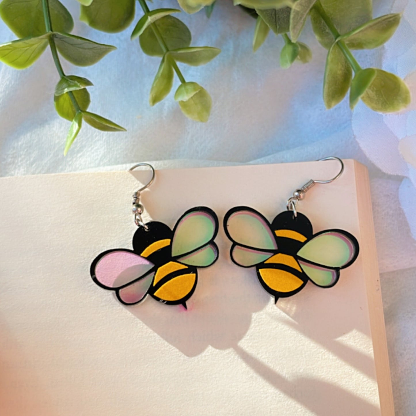 Baby Bee Earrings - Nian by Nidhi - placed in a white and green background