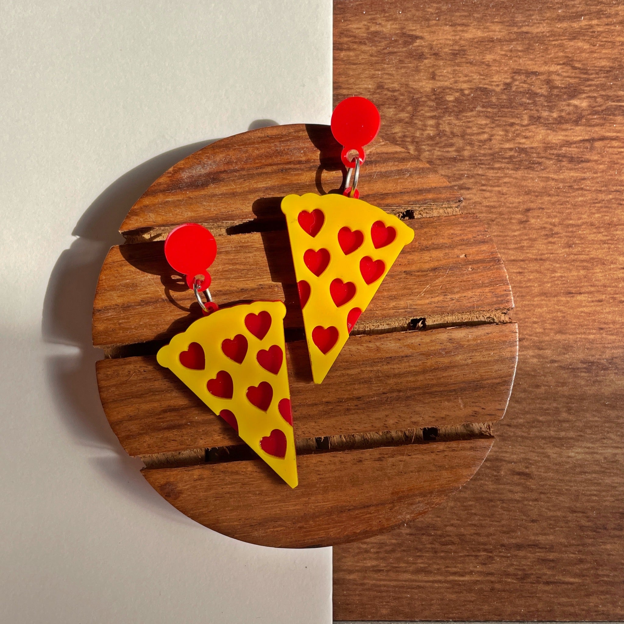 Pizza Earrings - Nian by Nidhi - placed in a white and brown background