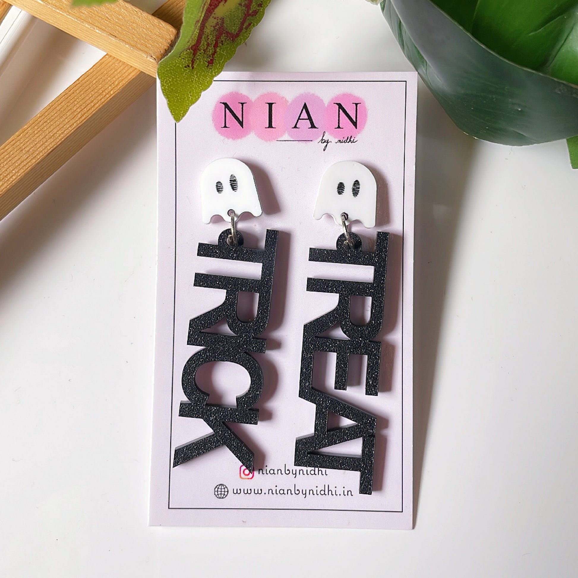 Trick or Treat Danglers - White and Shimmer black - Nian by Nidhi - placed in a white and green background