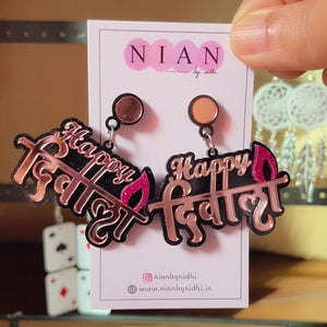 Happy Diwali Earrings - Rosegold and Pink on Black base - Nian by Nidhi - held in a hand