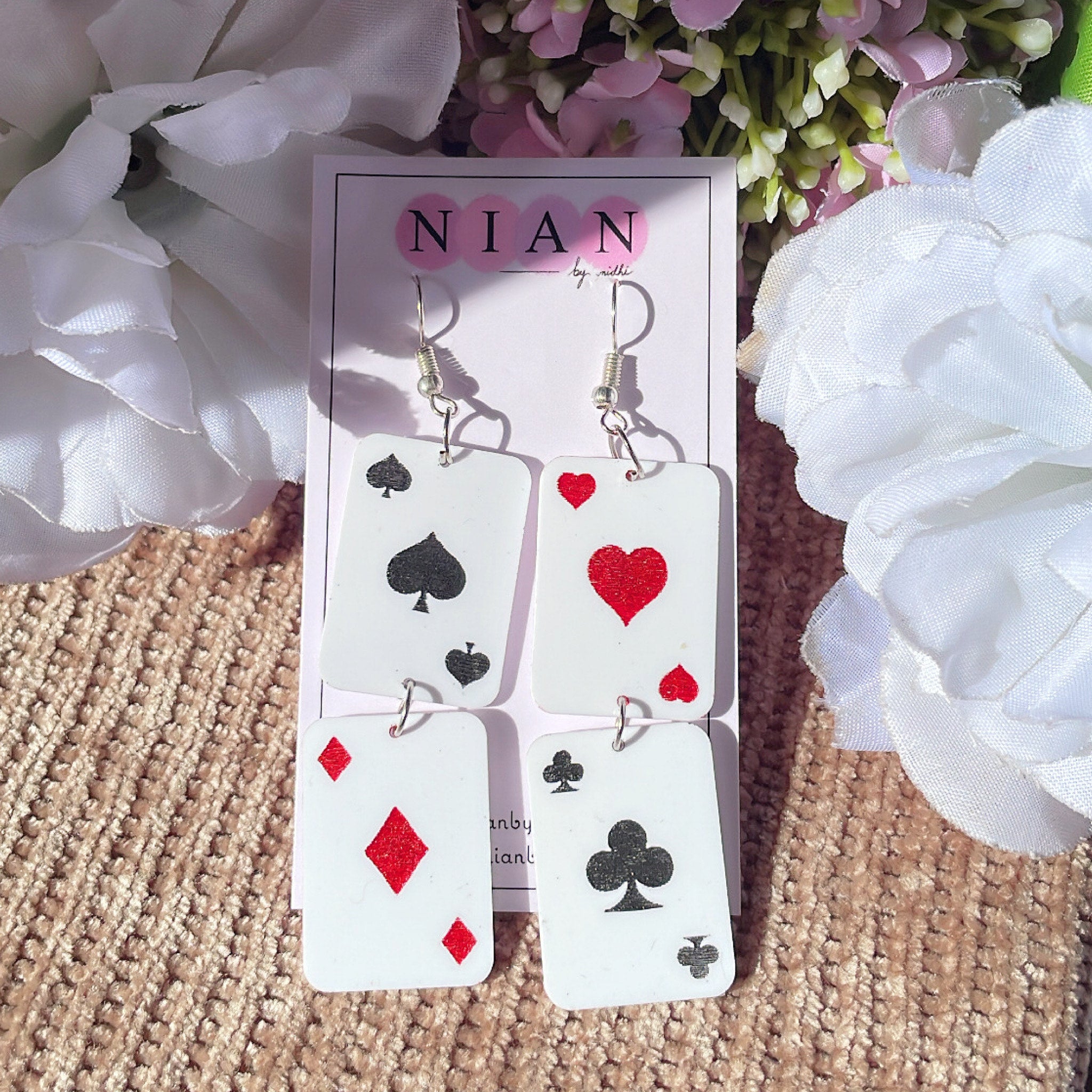 Poker Earrings - White - Nian by Nidhi - placed in a brown and white flower background