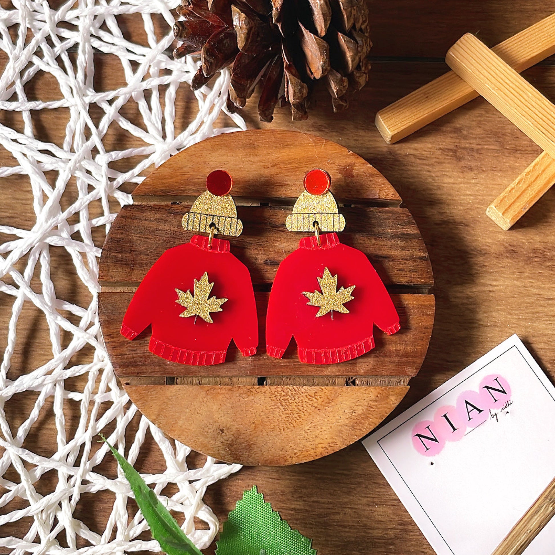 Wool Wrap Earrings - Red and Shimmer Golden - Nian by Nidhi - placed in a brown and white background
