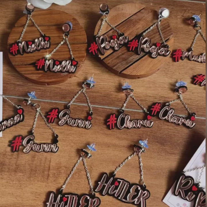 A glittering video of several Customised Alphabet Earrings - personalised with a various texts - red or pink and rose gold - Nian by Nidhi - in a brown background