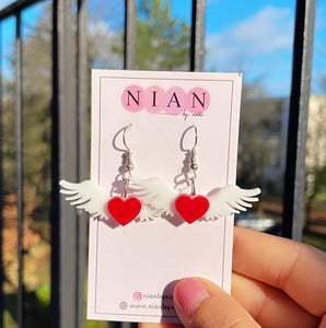 Angel of Hearts Earrings - White and Red - Nian by Nidhi - placed in a natural background with trees