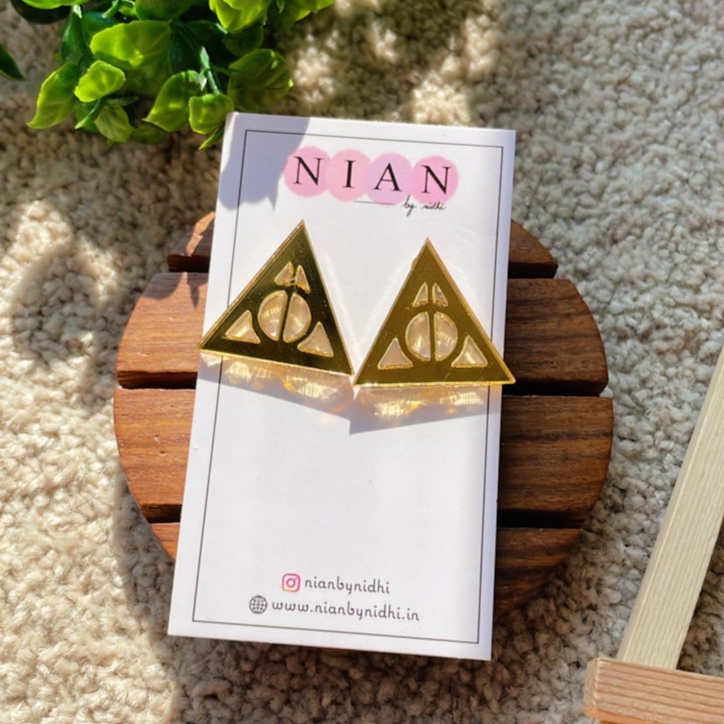 Deathly Hallows Studs - Glassy Golden - Nian by Nidhi - placed on a Nian by Nidhi earring card - in a light beige background