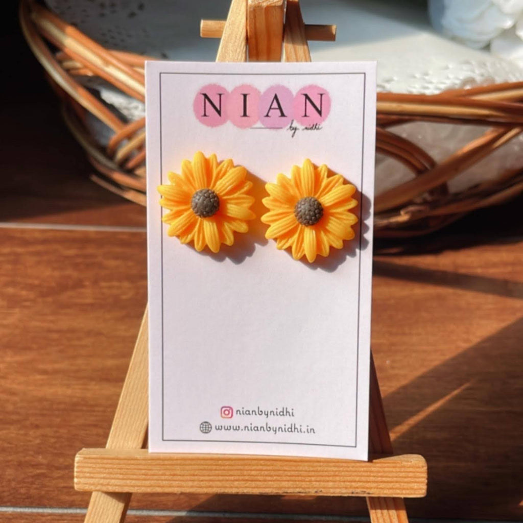 Sunkissed Sunflower Studs - Yellow - Nian by Nidhi - placed in a brown and white background