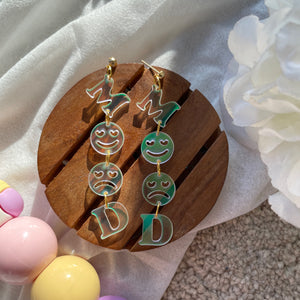Mood Earrings - Holographic - Nian by Nidhi - placed in a white flowery background