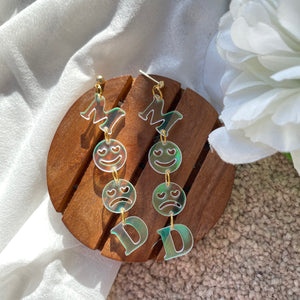 Mood Earrings - Holographic - Nian by Nidhi - placed in a white flowery background