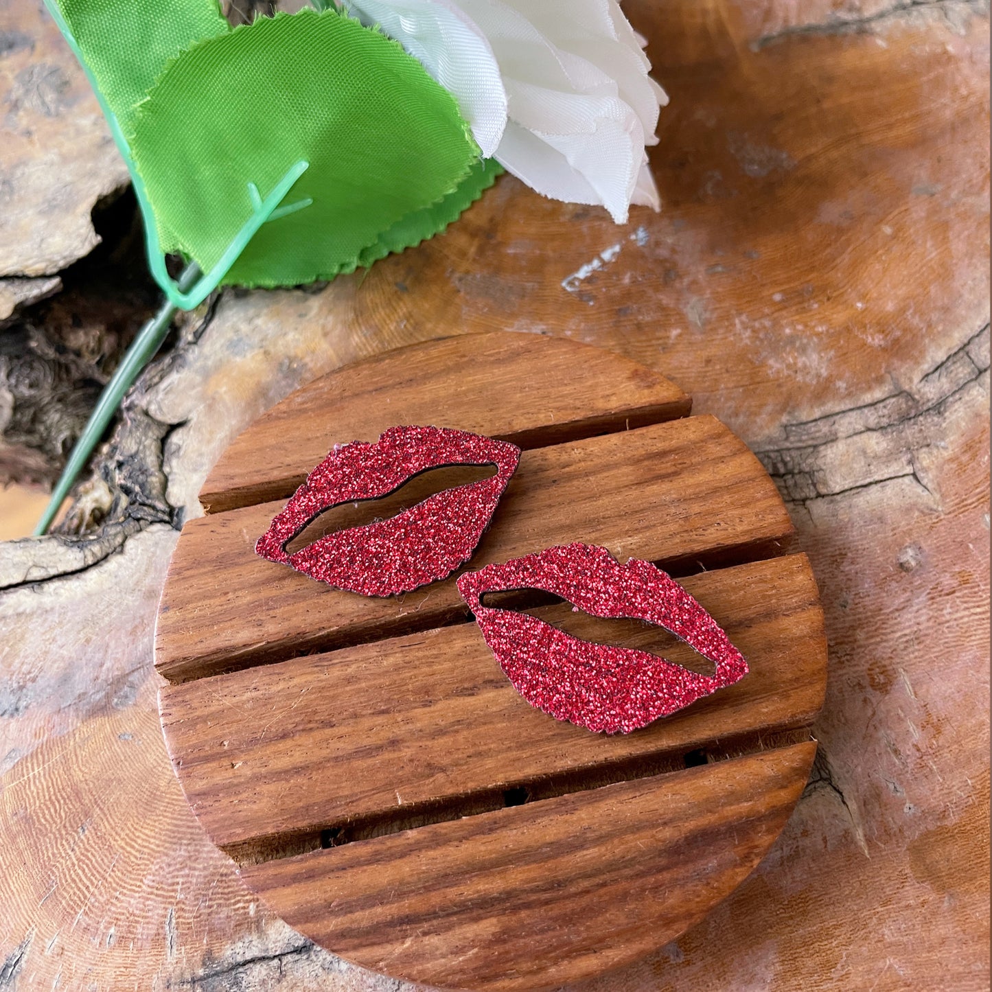 Shimmer Lips Studs - Red - Nian by Nidhi - in a white, green, and brown background