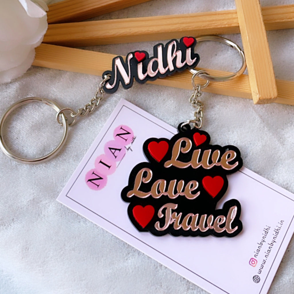 Customised Alphabet Keychain - Rose gold + Red and Pink - Nian by Nidhi - with the text "Nidhi" and "Live Love Travel", placed in a white and brown background