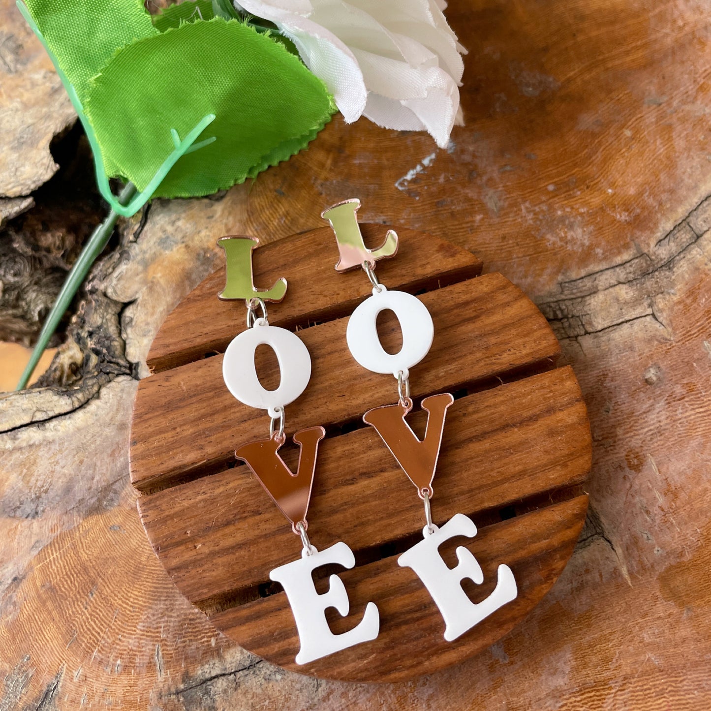 Rosegold Love Earrings - Rosegold and white colors - contains acrylic based four letters of "LOVE" - Nian by Nidhi - in a white, green, and brown background