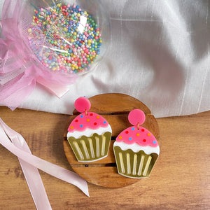 Cupcake Earrings - Pink, White, and Golden - Nian by Nidhi - in a white, brown, and a colorful background