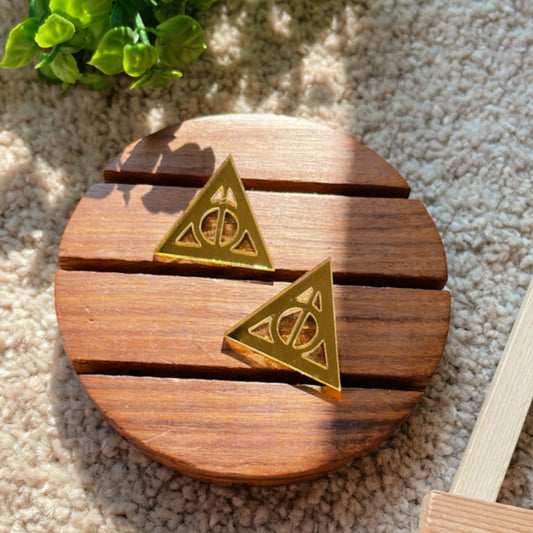 Deathly Hallows Studs - Glassy Golden - Nian by Nidhi - placed in a light beige background