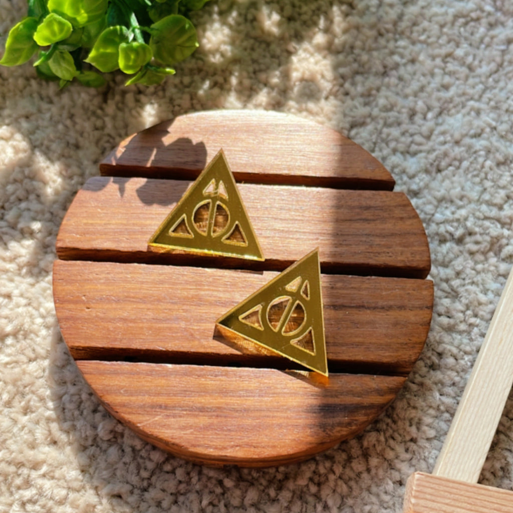 Deathly Hallows Studs - Glassy Golden - Nian by Nidhi - placed in a light beige background
