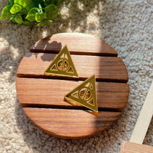 Deathly Hallows Studs - Glassy Golden - Nian by Nidhi - placed in a light beige background