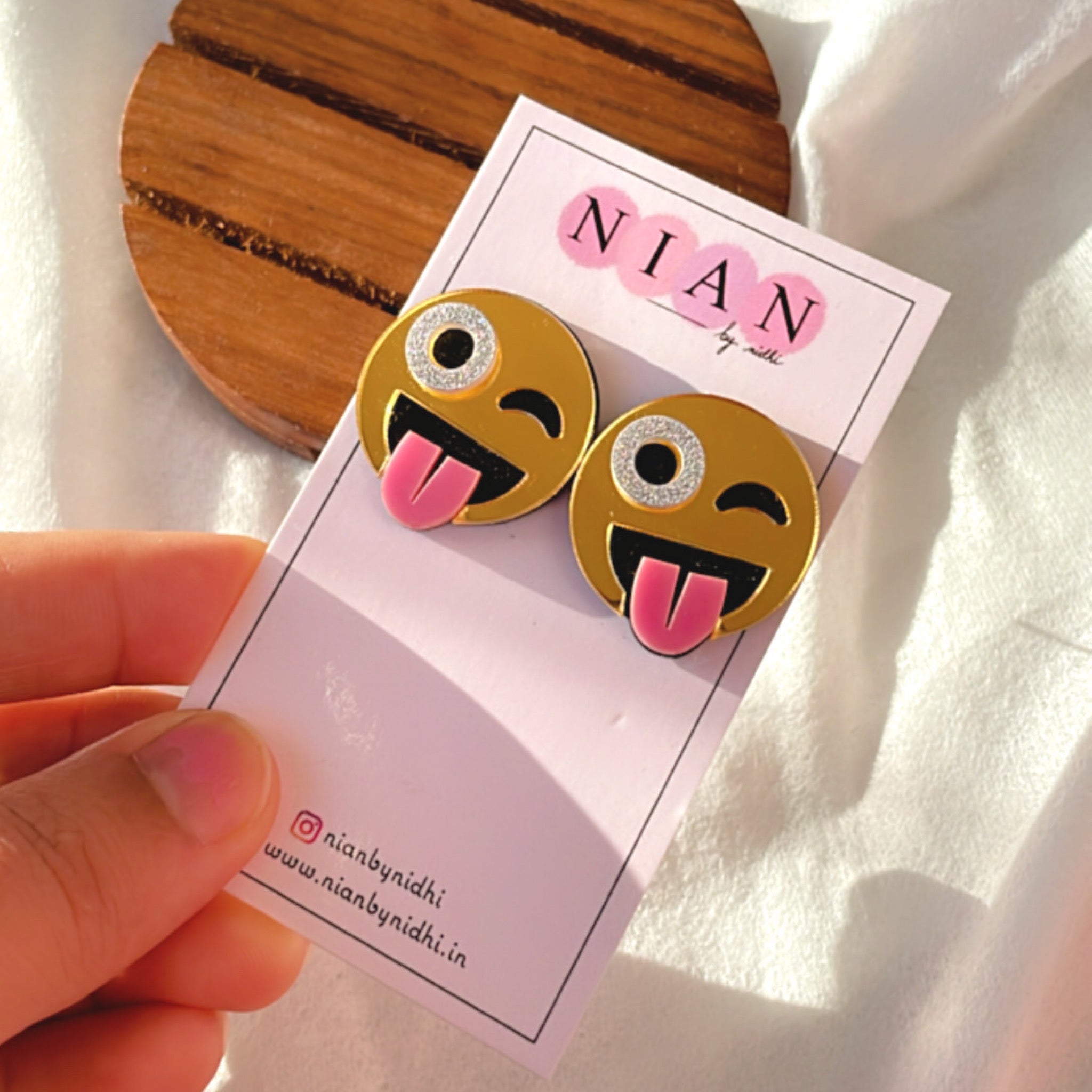 Goofy Emoji Studs - Golden with face detailings - Nian by Nidhi - placed in a brown and white background