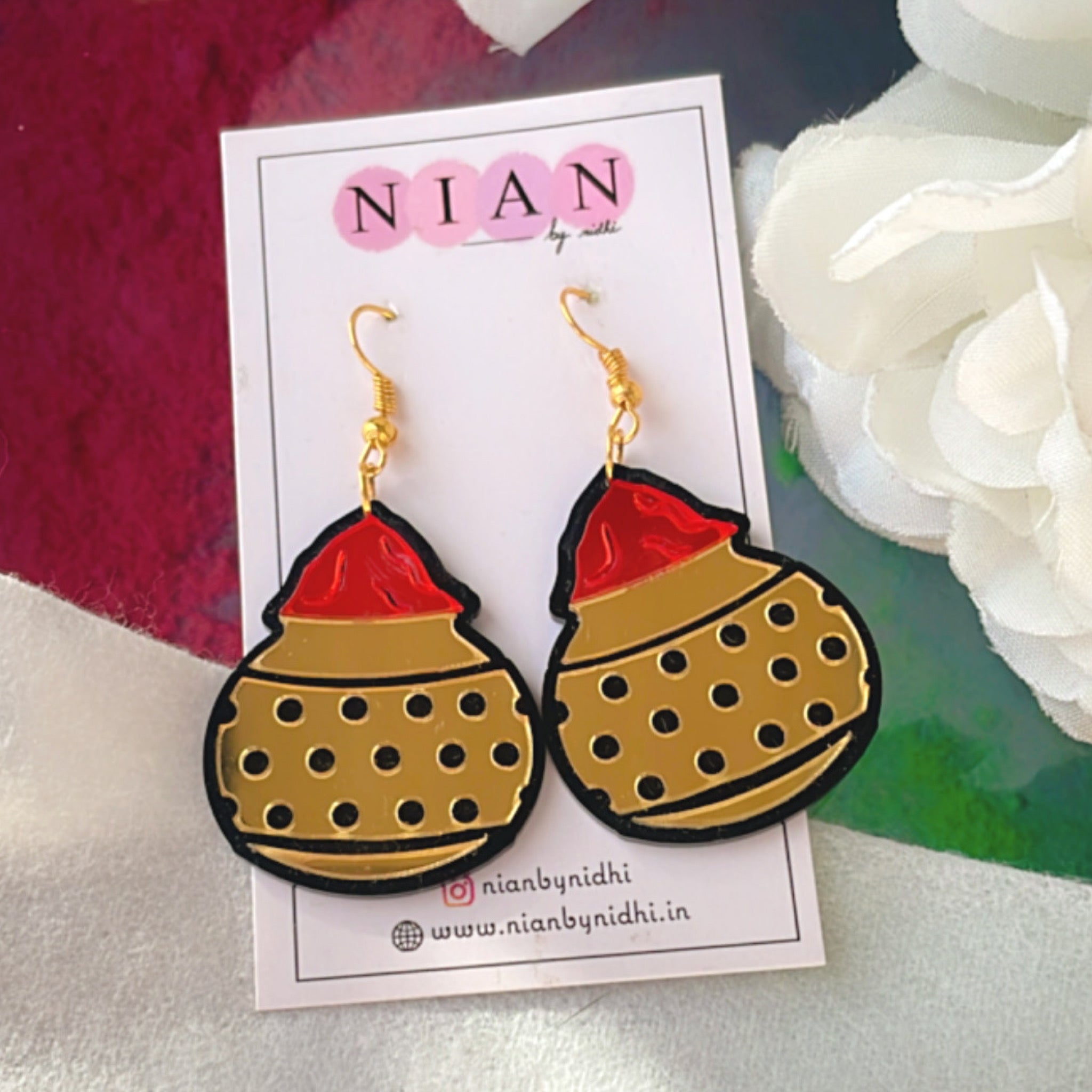 Gulal ki Matki Earrings - Glossy Golden and Red - Nian by Nidhi - placed in a colorful background