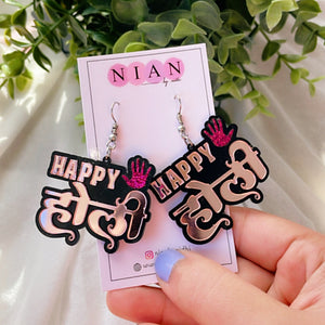 Happy Holi Earrings - Rosegold and Shimmer Pink - Nian by Nidhi - placed in a white and green background, held in a woman's hand