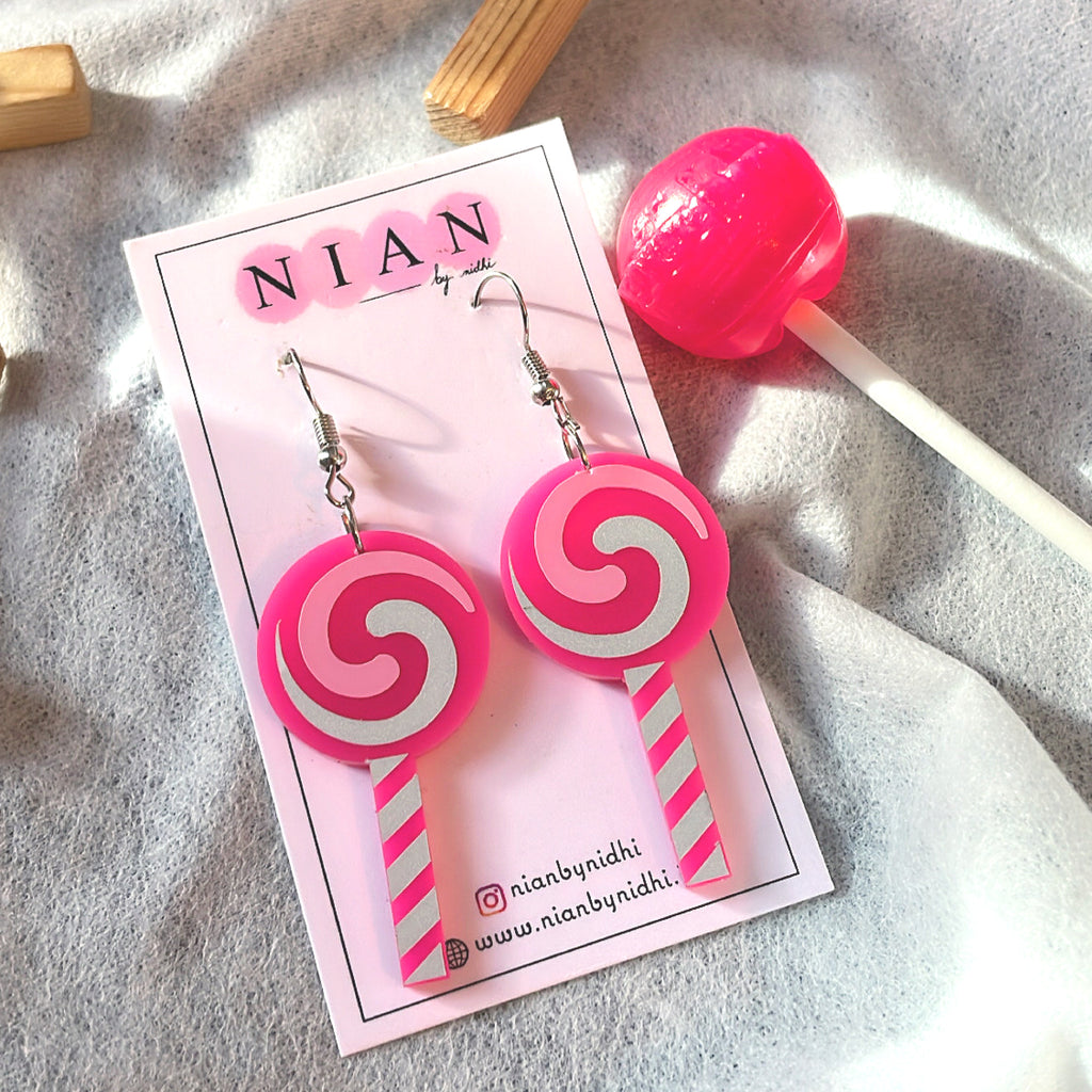 Lollipop Swirl Earrings - Pink and White - Nian by Nidhi - placed in a white background with a pink lollipop