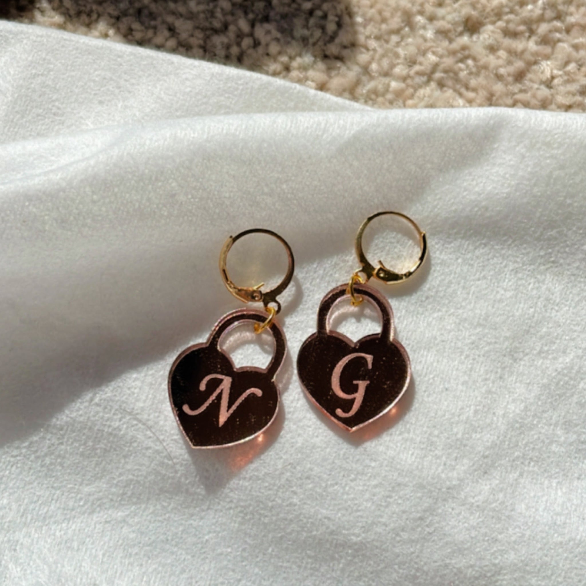 Initial Heart Lock Earrings - Glossy Rosegold - Nian by Nidhi - placed in a white background