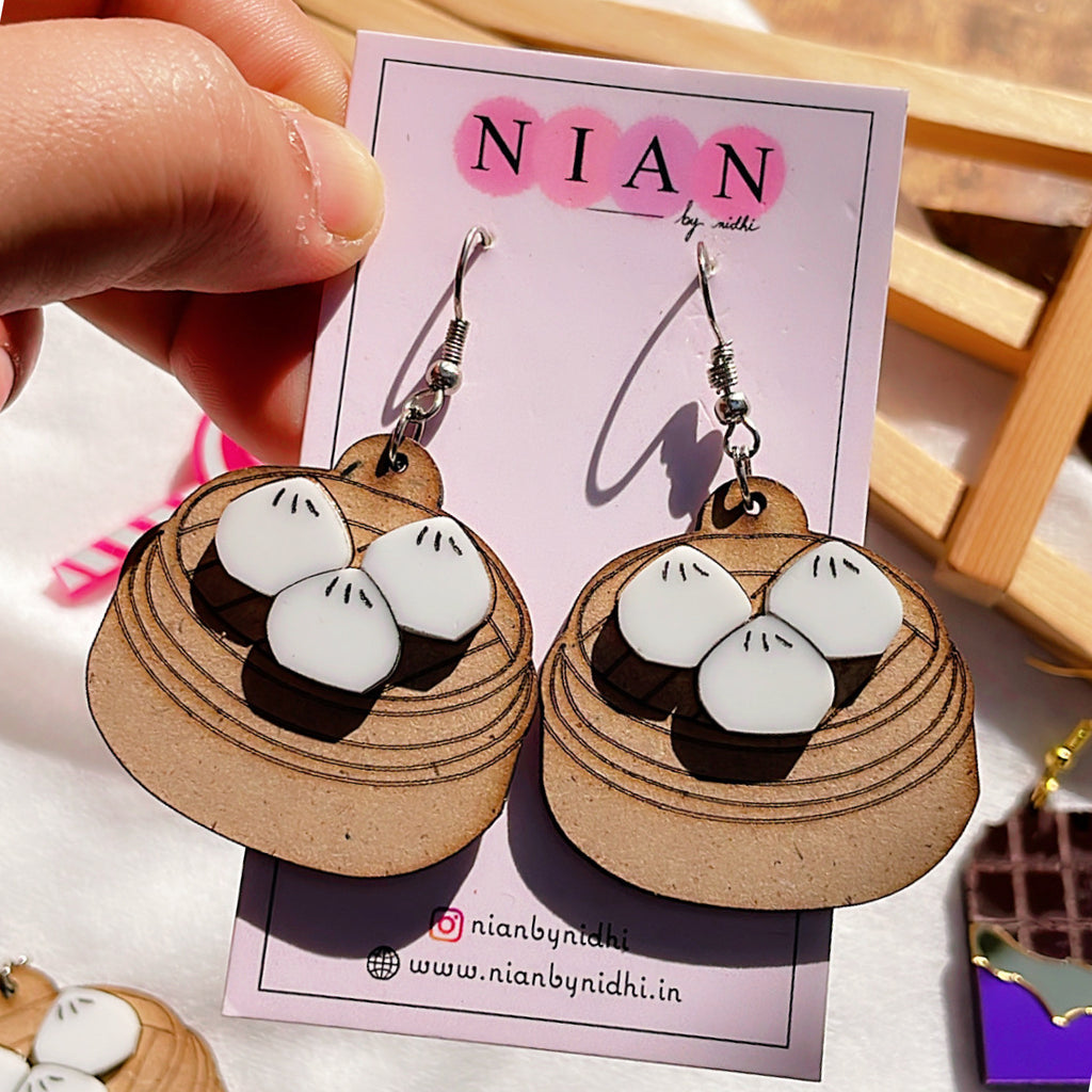 Momos Earrings - White and Brown - Nian by Nidhi - held in a woman's hand