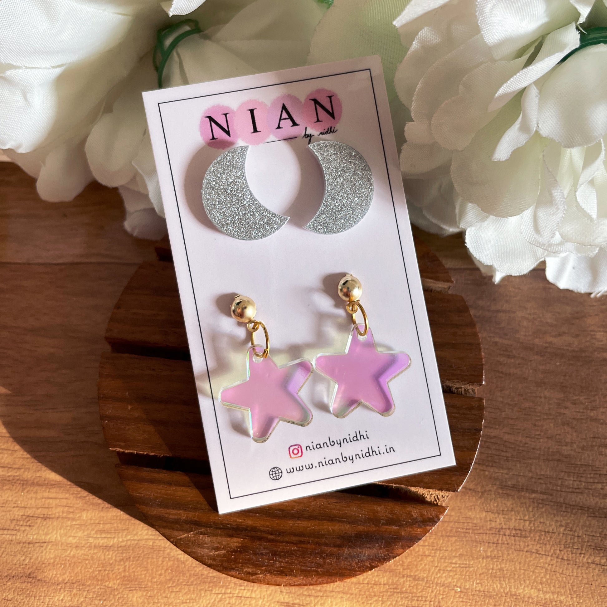 Nightsky Studs (Set of 2) - consisting Moon Studs and Star Studs - Shimmer Silver and Holographic colors - Nian by Nidhi - in a brown and white background, placed on Nian by Nidhi earring card