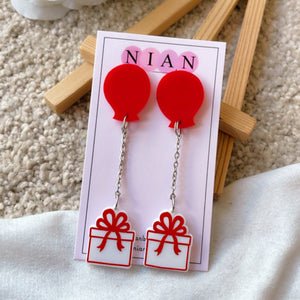 Balloon Gift Earrings - White and Red - Nian by Nidhi - placed in a brown and white background