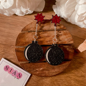 Pataka Earrings - Shimmer black and red - Nian by Nidhi - in a white and brown background