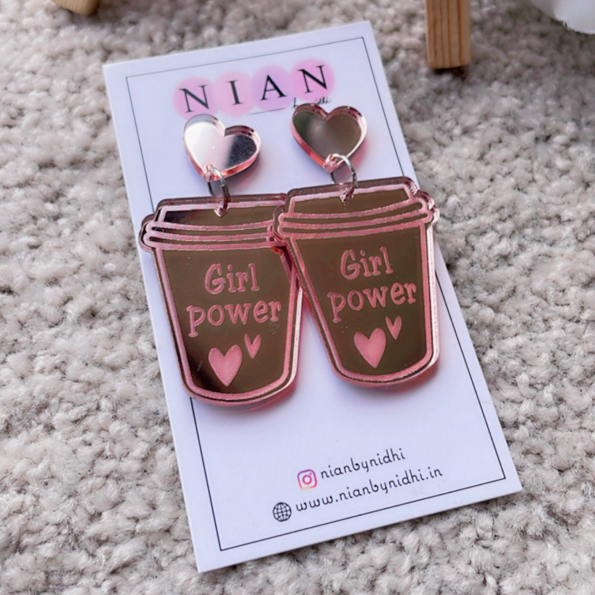 Girl Power Earrings - Nian by Nidhi - Rose Gold - placed in a light brown background