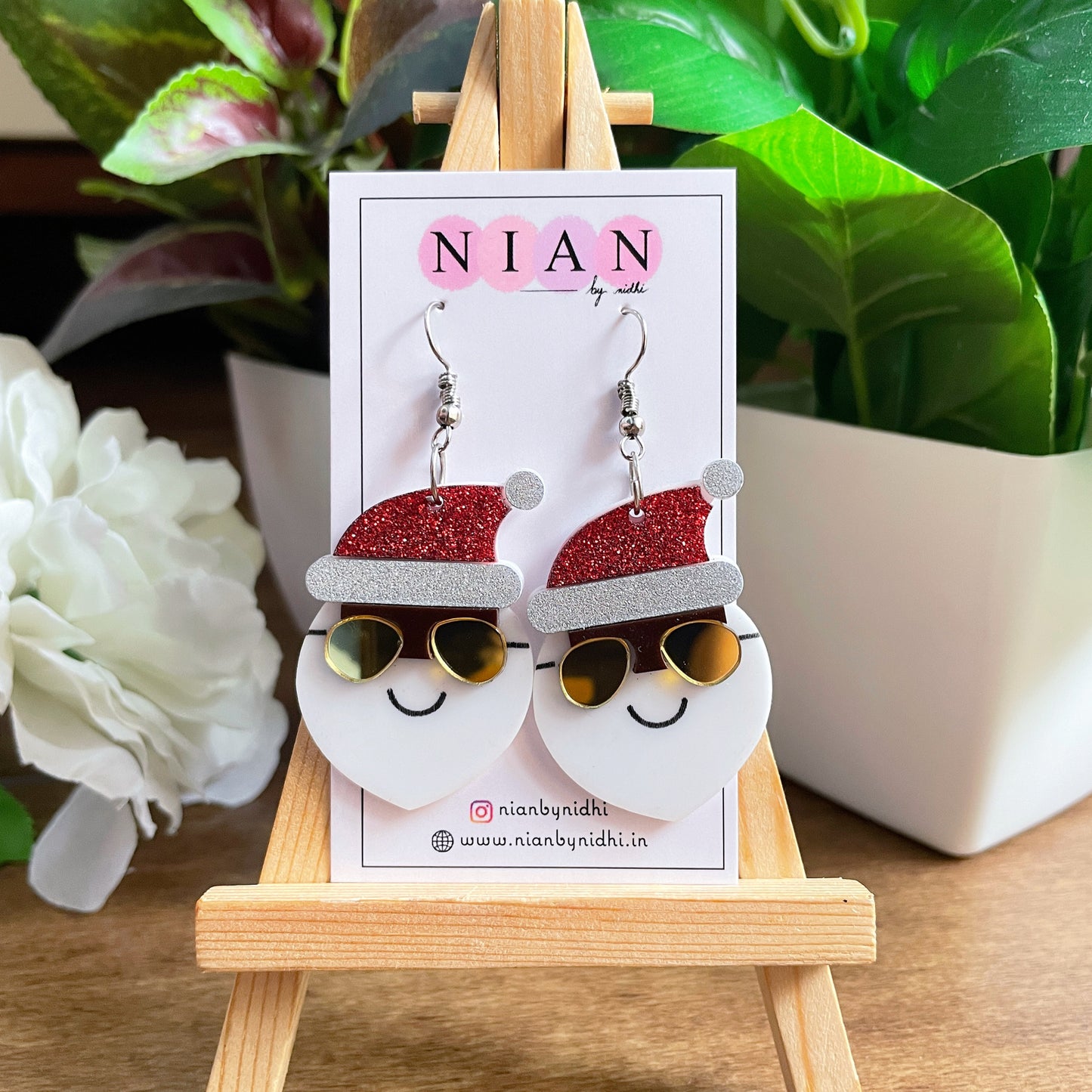Yo Santa Earrings - Red and White - Nian by Nidhi - placed on a small wooden canvas, inside a Nian by Nidhi Earring card