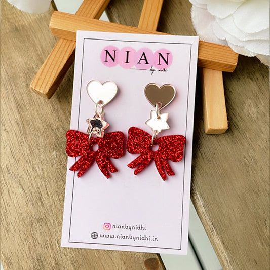 Bow Danglers - Shimmer Red and Rosegold - Nian by Nidhi - placed in a brown background