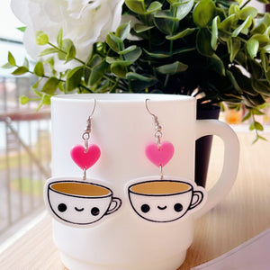Candid Coffee Earrings - White, Pink & Brown - Nian by Nidhi - placed with a green plant in the background