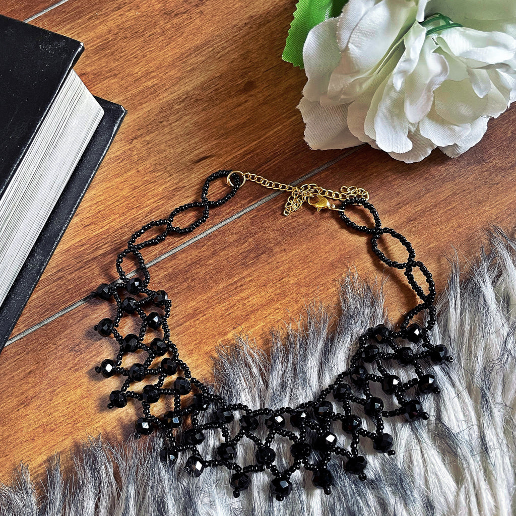 Black Crystal Chocker - Nian by Nidhi - in a brown background with a book and a flower
